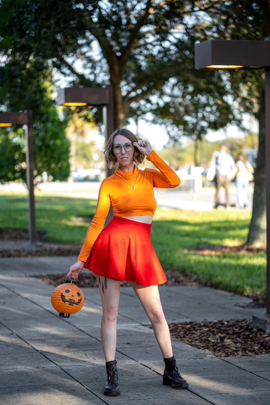 woman in orange long sleeves and skirt holding pumpkin basket