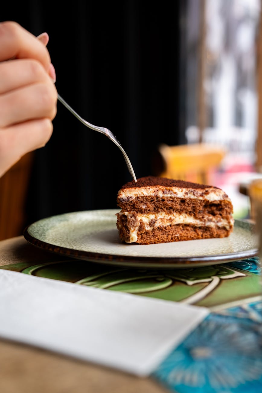 close up of tiramisu slice in cozy cafe setting