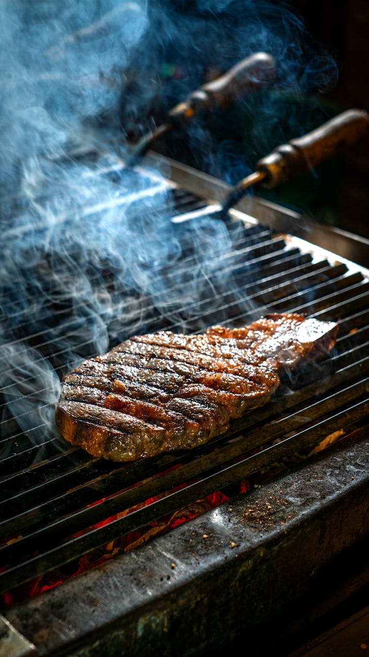 smoky grilled steak on outdoor bbq grill