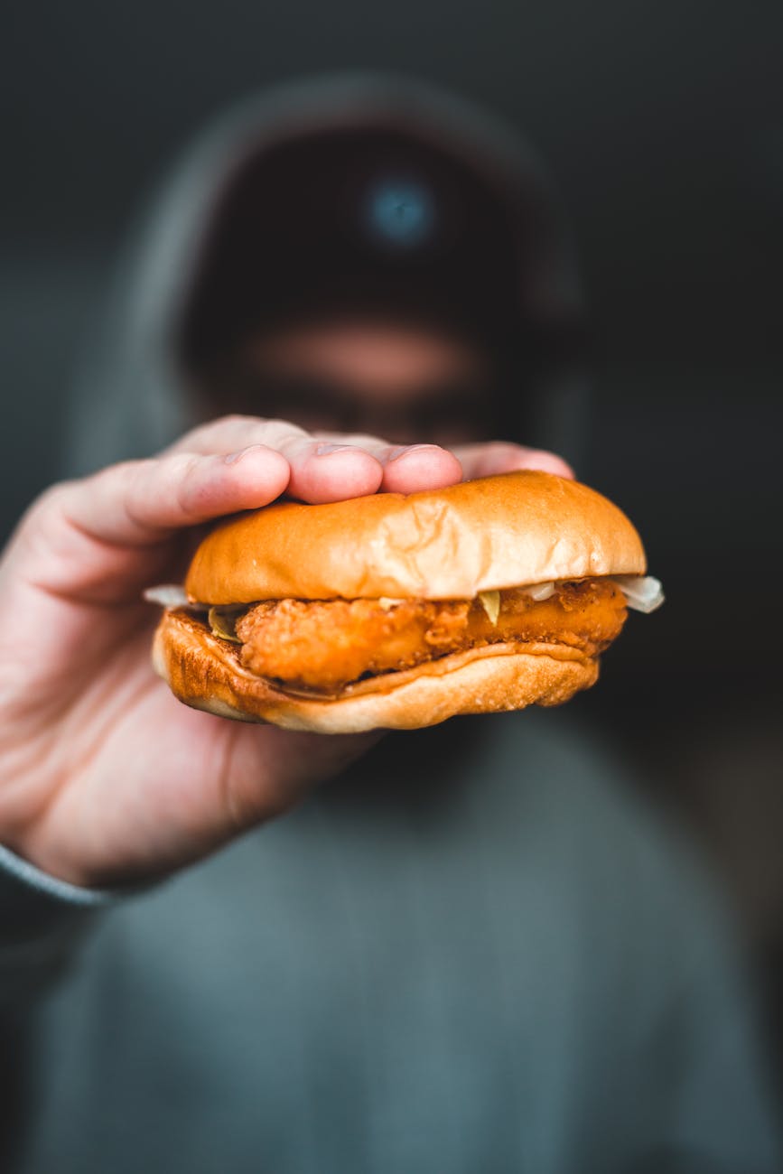 anonymous man demonstrating burger with cutlet