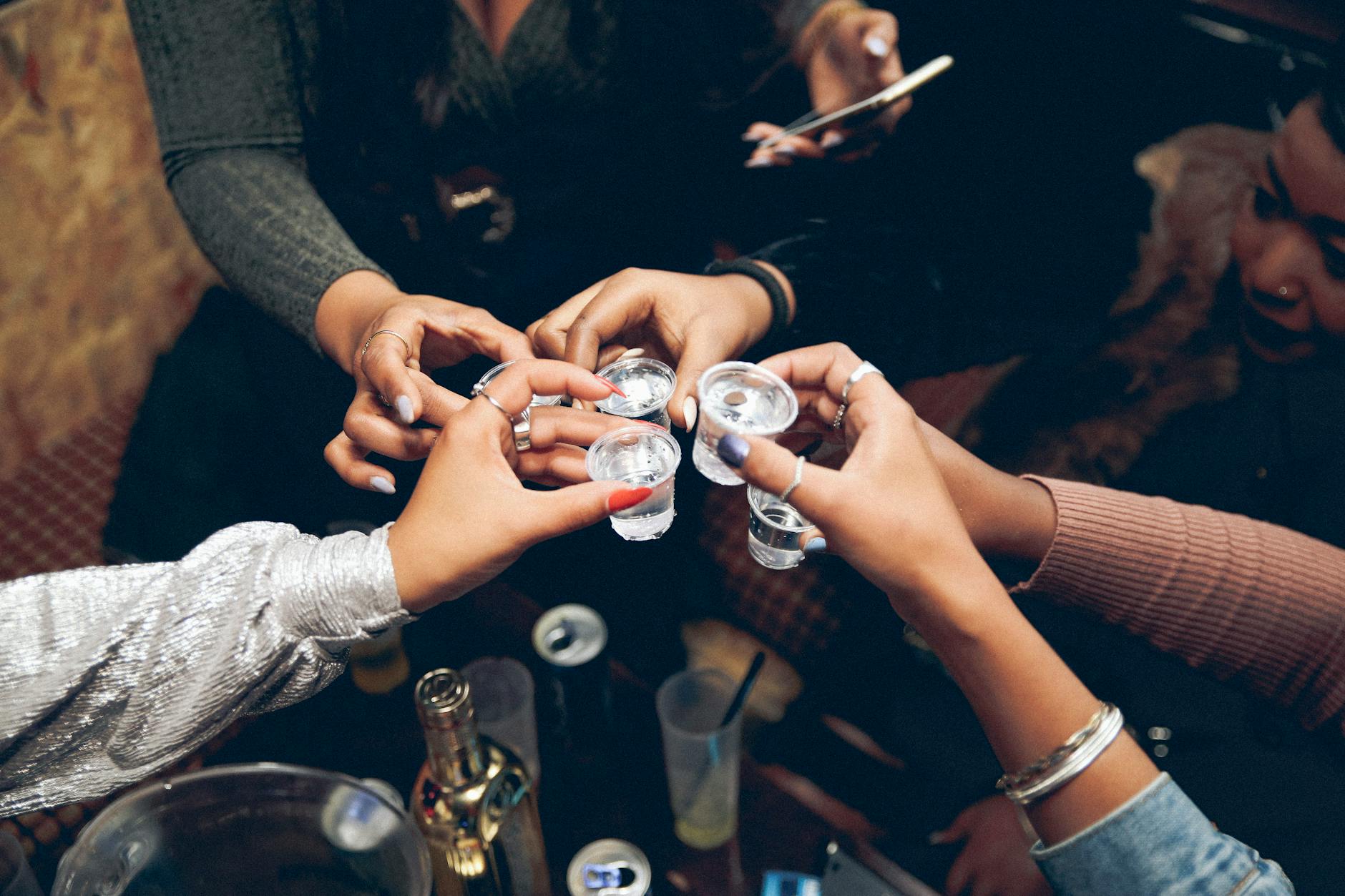 people clinking glasses with alcohol drink