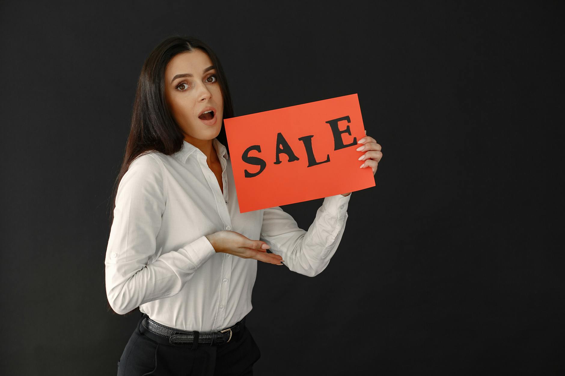 surprised woman holding sale sign