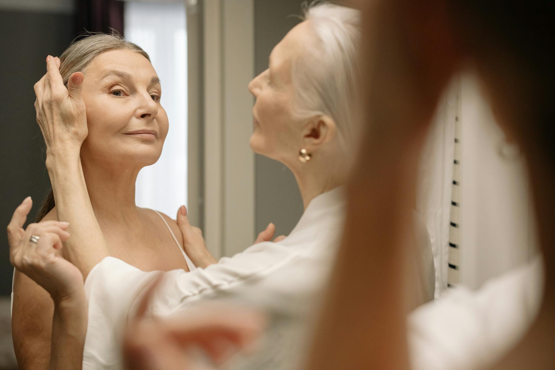 elderly couple standing in front of a mirror and smiling