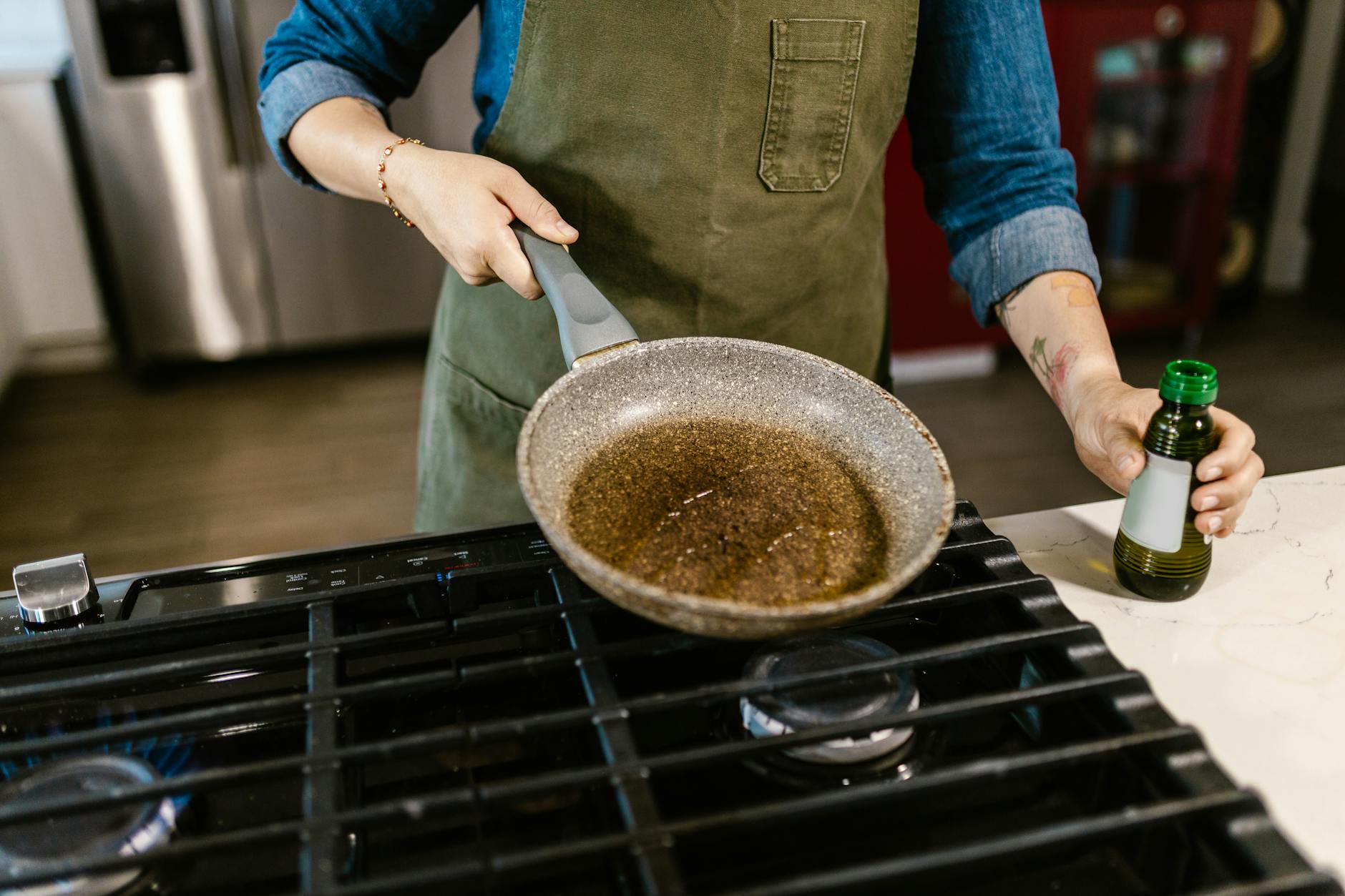 chef spreading olive in frying pan