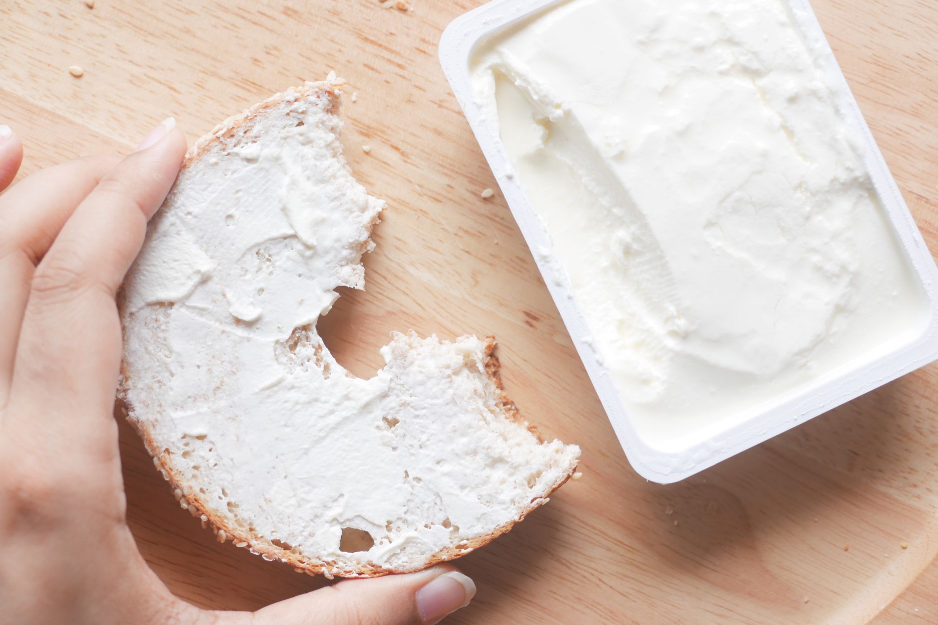 a person holding brown bread with cream