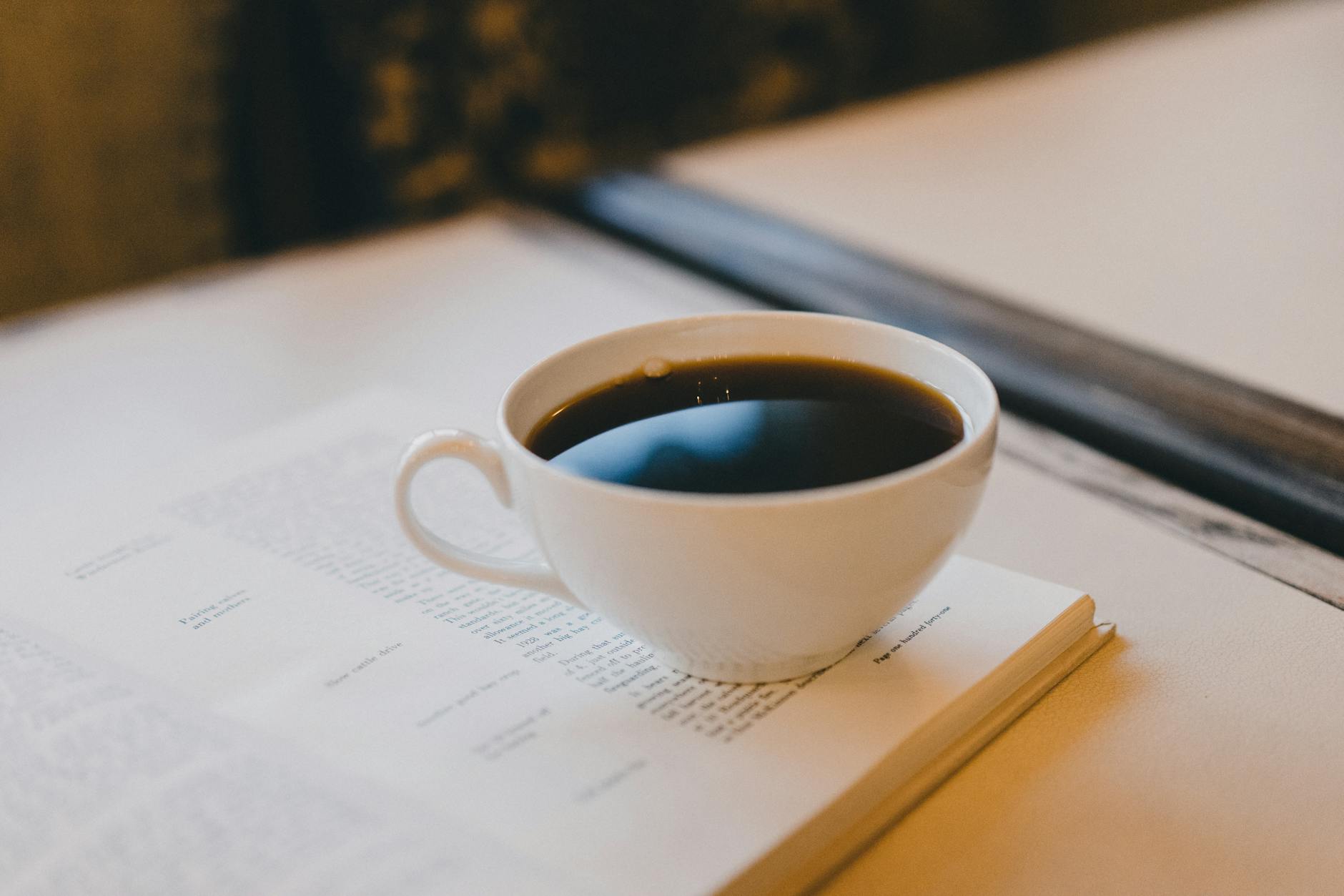 a cup of coffee on an open notebook