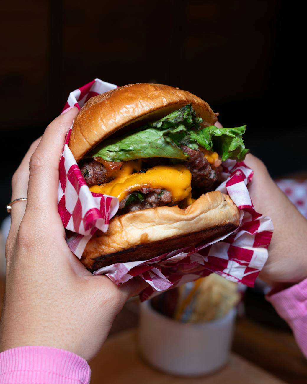 a person holding a burger