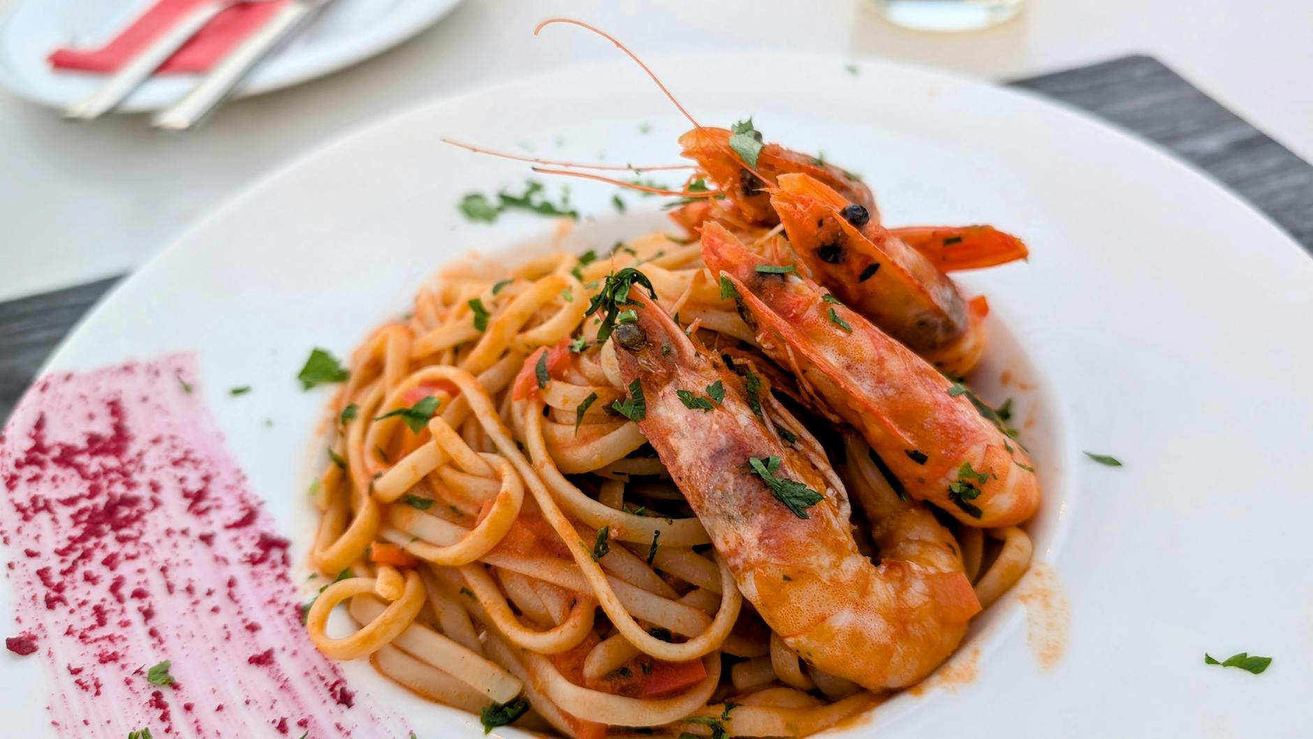a white plate topped with pasta and shrimp