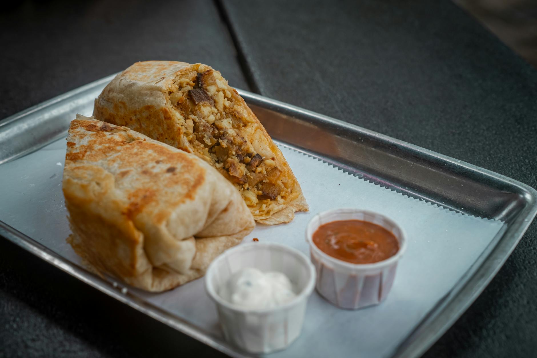 delicious breakfast burrito with salsa and sour cream