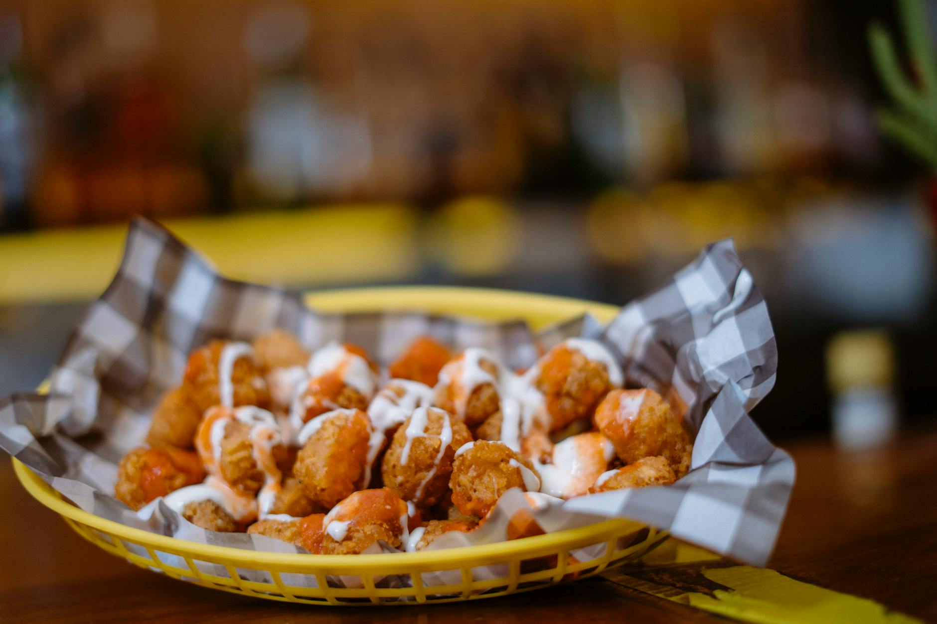 close up of tater tots with drizzle sauce