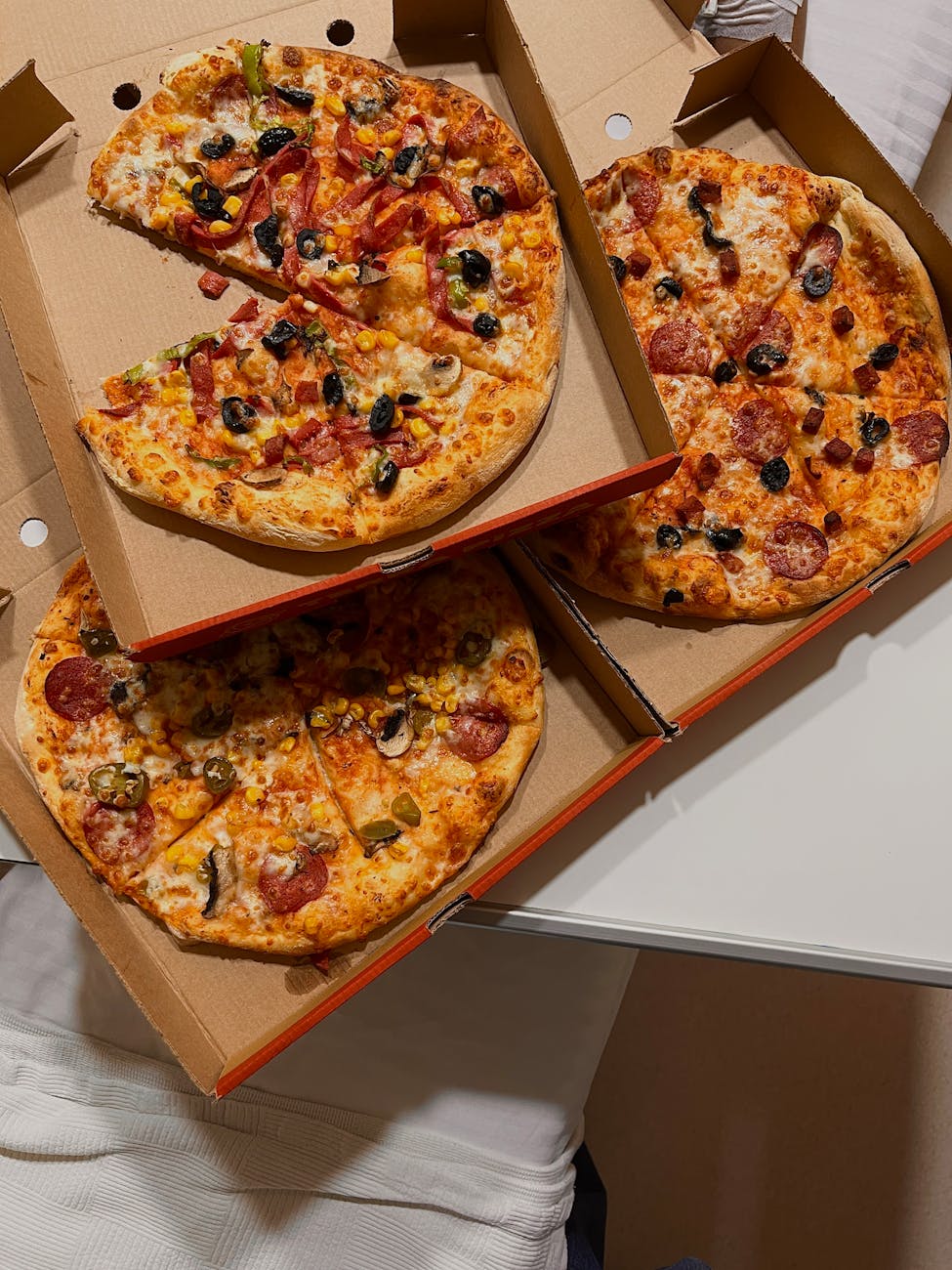 delicious assorted pizzas in cardboard boxes