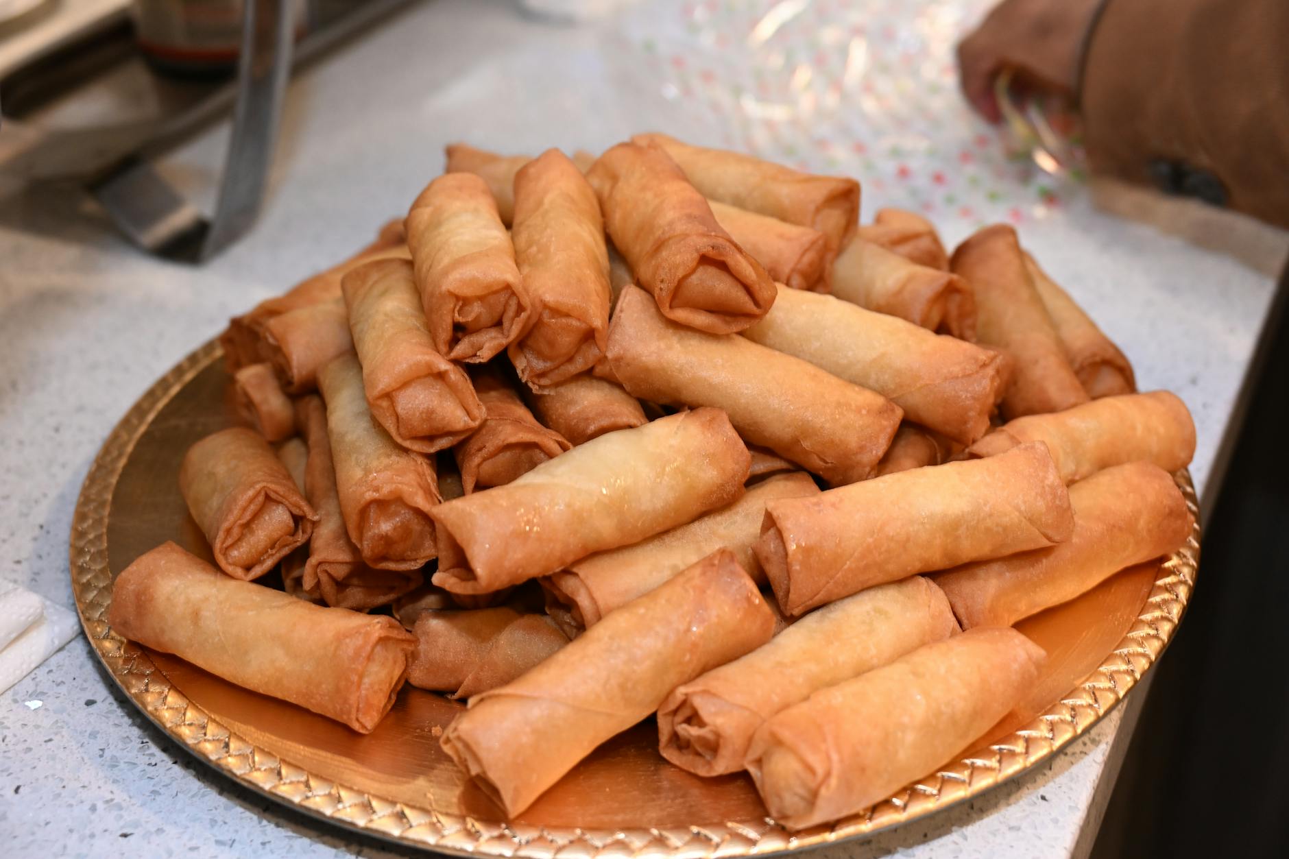 close up of freshly made spring rolls on a tray
