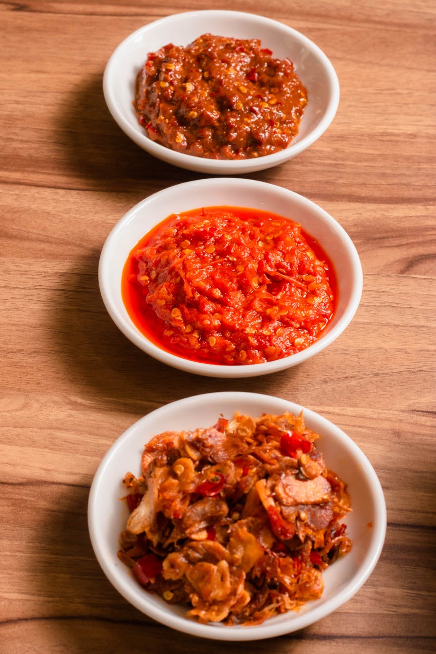 delicious assorted chili sauces on wooden surface