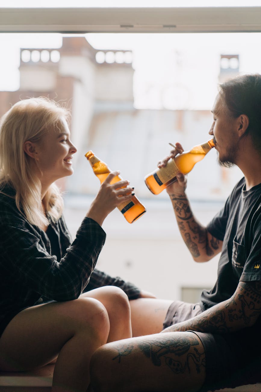 a man and woman drinking bottles of beer