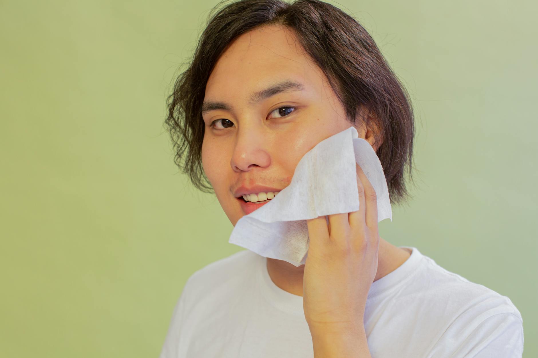 content asian man wiping face