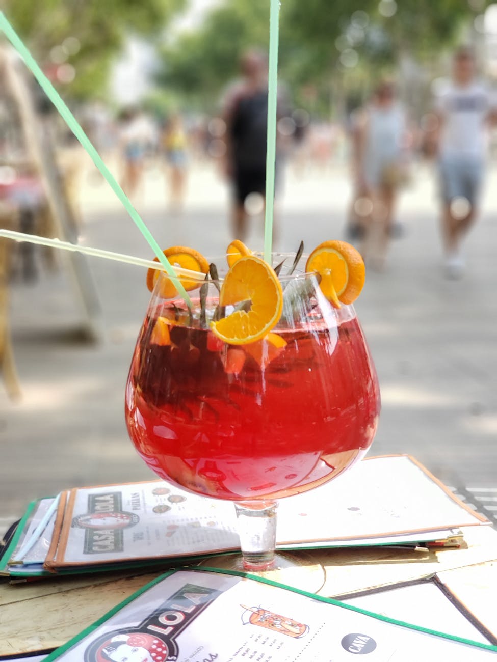 a glass of cocktail with straws