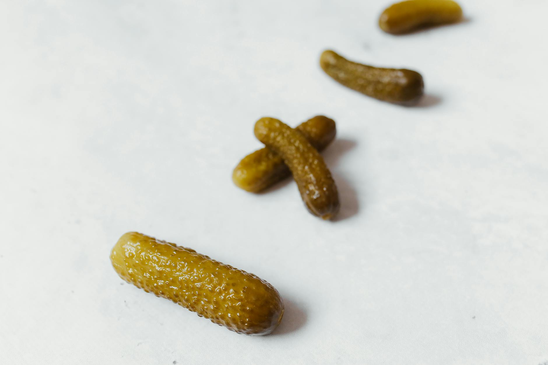 pickled cucumbers on white surface