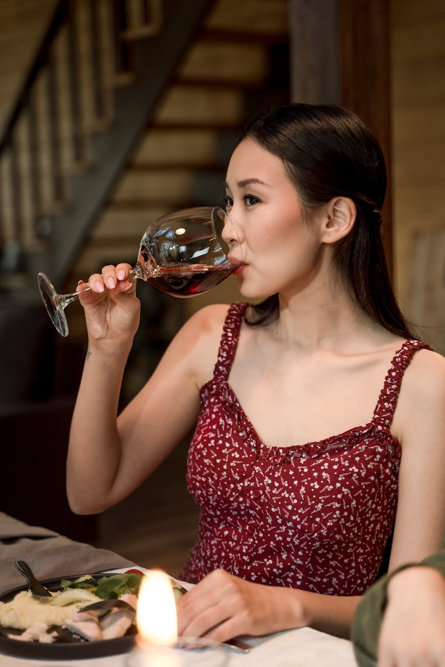 a woman in floral dress drinking red wine