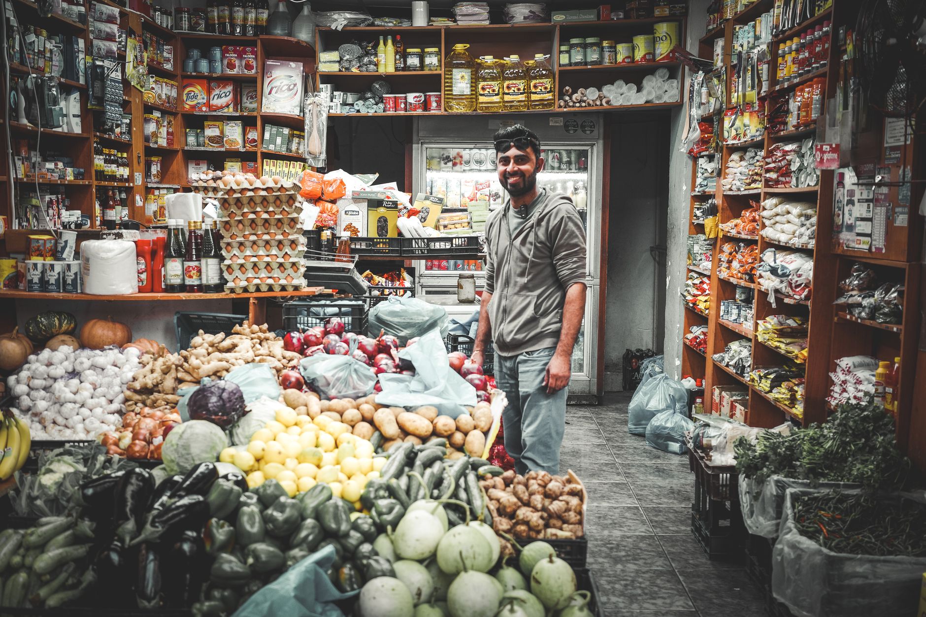 man in gray sweater standing inside a store